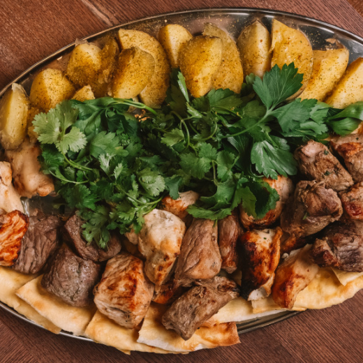 Assorted five types of kebab with potatoes, pickled onions and herbs.